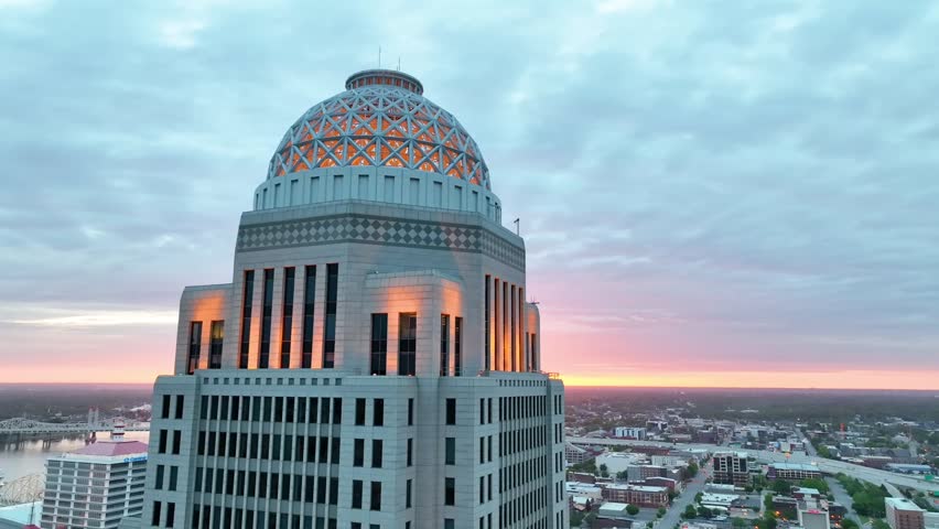 Close up of Louisville downtown buildings with gorgeous sunrise cresting horizon aerial video