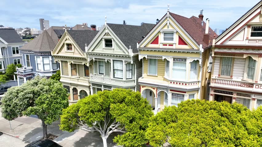 Aerial video close up of famous Painted Ladies houses boom up to San Francisco city
