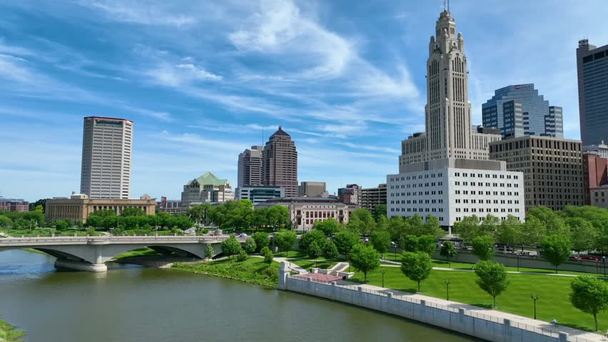 Slow tilt up of aerial video over downtown Columbus Ohio with river and LeVeque Tower