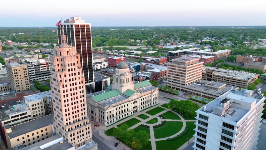 Courthouse and other downtown buildings with moving train in sunset aerial video