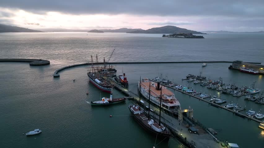 Aerial of Hyde Street Pier at sunset wide shot of San Francisco Bay with Alcatraz Island Royalty-Free Stock Footage #1107231961