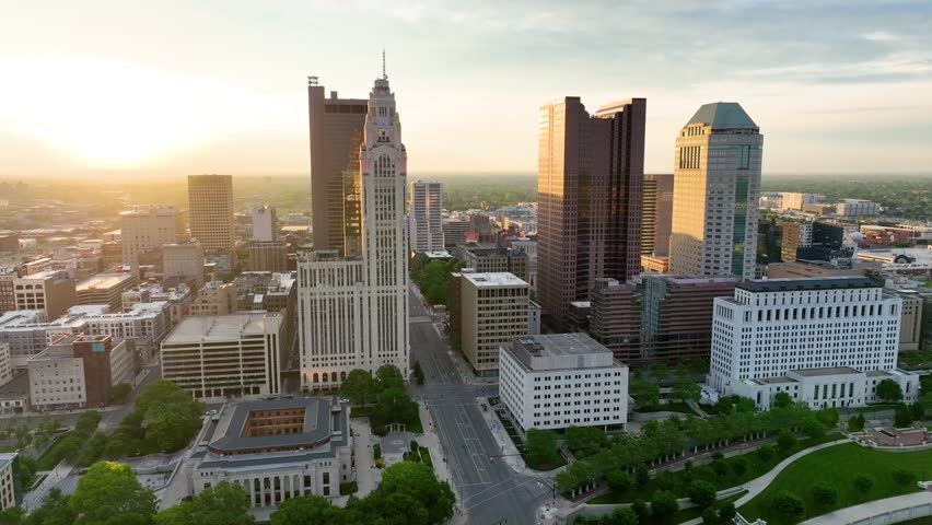 Wide angle of sunrise hitting Columbus OH skyscrapers aerial video from above river
