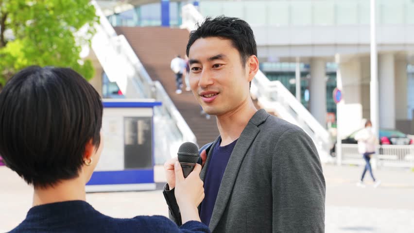 Asian man being interviewed on the street. TV broadcasting. Interviewee. Royalty-Free Stock Footage #1107232387