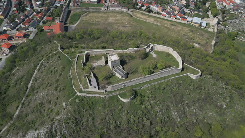 Aerial view of ruined castle on hill, city Hainburg an der Donau and Danube river in Austria, 4k
