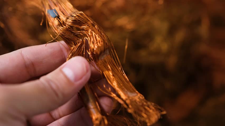 Man's hand holding copper wire for recycling	