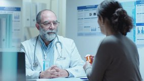 Senior doctor sitting behind the table in clinic, giving pills to female patient and telling the dose during medical appointment - Powered by Shutterstock - Get 15% off with code: PIKWIZARD15
