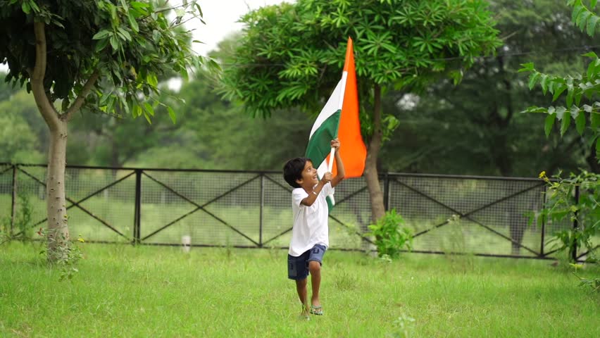 Cute little Indian kids holding, waving or running with Tricolour with greenery in the background, celebrating Independence or Republic day