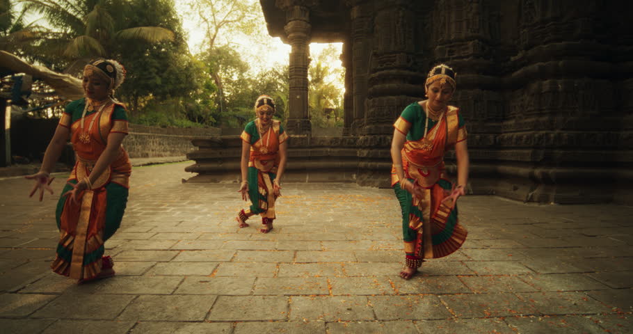 Slow Motion Portrait of Indian Women in Traditional Clothes Dancing Bharatanatyam in Colourful Sari. Three Expressive Young Females Performing Folk Dance Choreography in an Ancient Temple