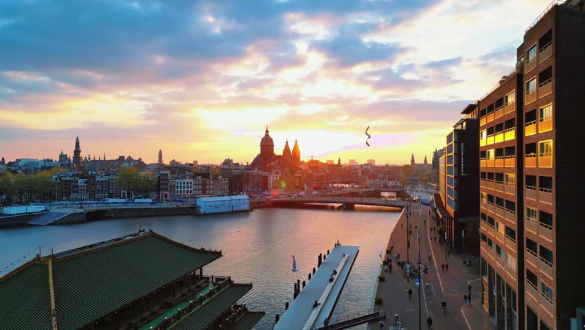 Aerial image rising with drone the banks of the river Amstel. lots of light, nature, urbanism, architecture, city center, sky, clouds, sunset, people, transport, cars, Netherland.
Canal Amsterdam.