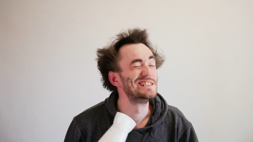 Young homeless man is excited about the upcoming changes in his life. Man blow drying his regrown hair. Mad man | Shutterstock HD Video #1107261539