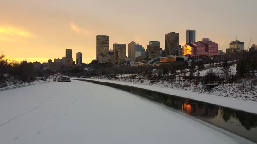 A drone view over the partially frozen North Saskatchewan River in Edmonton during the sunset