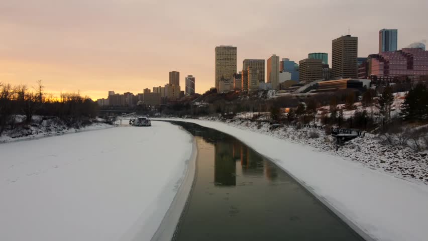 A drone view over the partially frozen North Saskatchewan River in Edmonton during the sunset