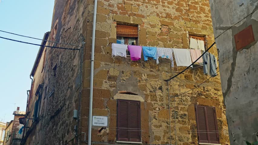Typical Street With Clothes Line Hanging In The Medieval Village Of Pitigliano In Tuscany, Italy. Low Angle Shot Royalty-Free Stock Footage #1107267941