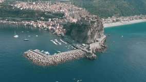 An aerial video of city buildings and mountains on the sea shore in Reggio Calabria, Italy