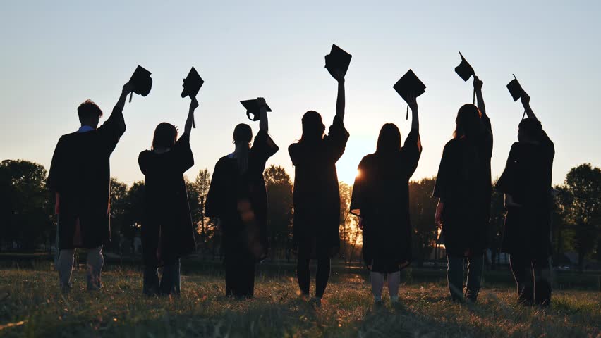 Silhouette of fresh graduates throwing their motarboard or trencher up in the air after their graduation. | Shutterstock HD Video #1107269061