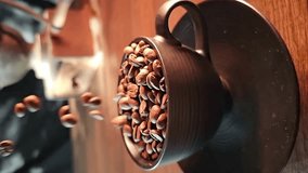 Coffee bean, coffee beans falling in super slow motian into a black cup on rustic surface, vertical video.