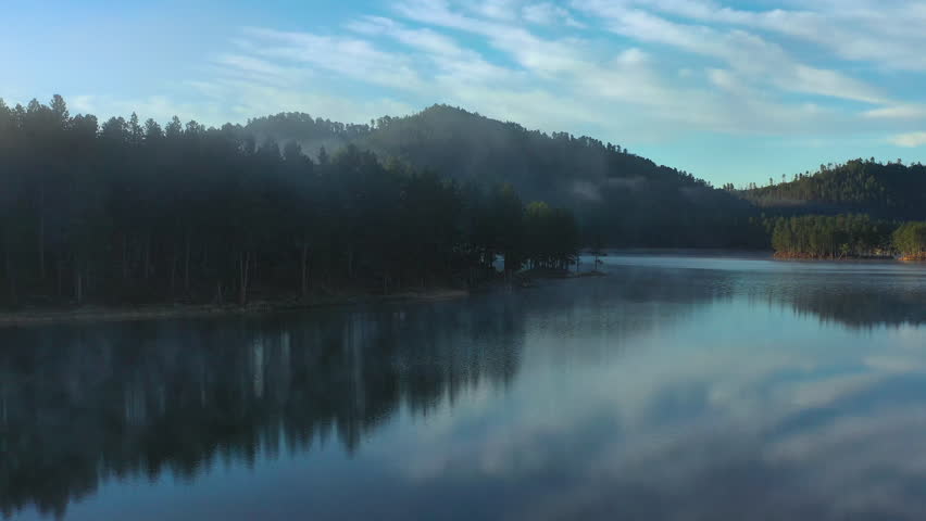 Pedestal rise over a mirror-like lake in the Black Hills of South Dakota