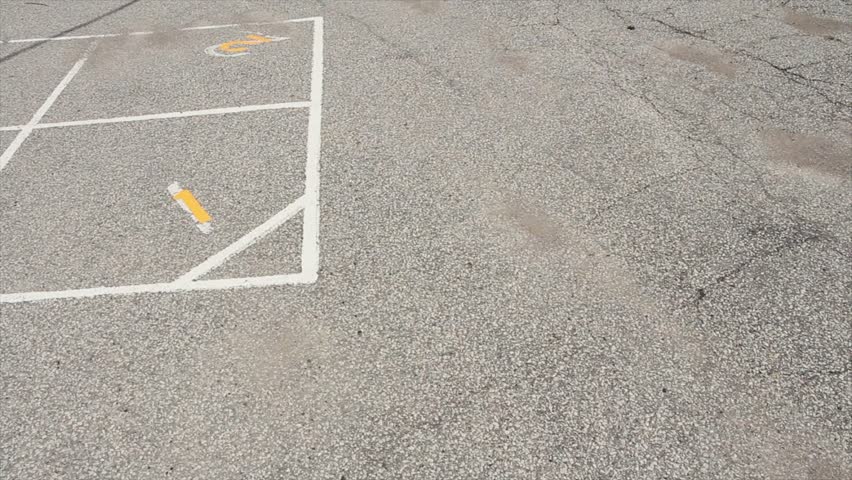 pan left on children outdoor four square school yard game printing in white and yellow with one two three four on pavement - one in foreground and three in background..