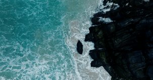 Aerial view Video Sea waves view top-bottom, monsoon sea waves, large ocean waves roll into sandy beach, a magnificent natural scene. Filmed with high quality film cameras. DCI 4K ProRes422