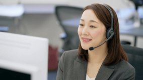 Asian operator wearing a headset to call a customer in a call center. - Powered by Shutterstock - Get 15% off with code: PIKWIZARD15