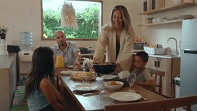 Family of Happy Man and Woman with Young Children Eating Food at Dinner Table in Home Kitchen. Parent Serving Prepared Lunch Meal or Breakfast for Kids. View on Emotional Bonding at Siblings Gathering - Powered by Shutterstock - Get 15% off with code: PIKWIZARD15