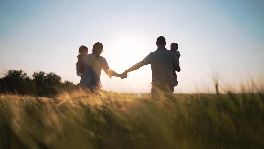 Happy family.group of people walk together holding hand in wheat field at sunset.family hold babies in their arms.Family day outdoors in summer in wheat field.Silhouette of happy family in wheat field Royalty-Free Stock Footage #1107285249