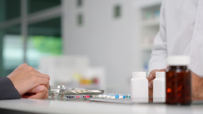 Close up hands of Handsome asian male selling pharmacist and female customer buying medicine in the pharmacy drugstore, hand over capsule pills bottle of medicine from hand to another hand charge. Royalty-Free Stock Footage #1107286231