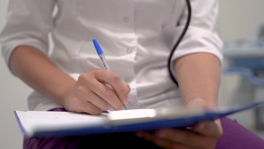Close Up Of The Hands Of A Female Doctor Writing The Symptoms And Treatment Of A Patient Royalty-Free Stock Footage #1107288761
