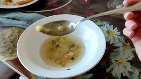 Woman eats vegetable soup at the table, first person video