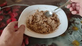 Man stirs buckwheat porridge in a plate, first person 4K video