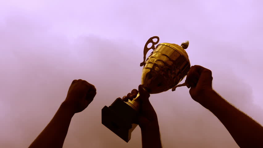 Winners celebrating a trophy at sunset, 4K video Royalty-Free Stock Footage #1107291763