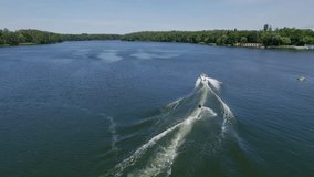 Motorboat pulling waterski on a lake in the forest, drone shot - Powered by Shutterstock - Get 15% off with code: PIKWIZARD15