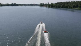 Motorboat pulls Cockpit Tube on a lake, following drone shot - Powered by Shutterstock - Get 15% off with code: PIKWIZARD15