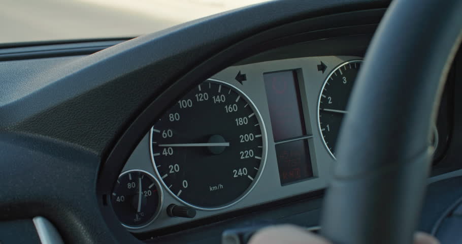 Close-up of car speedometer. Female hands hold the steering wheel and the speedometer needle picks up speed. High quality 4k footage