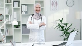 Portrait of smiling female doctor pediatrician in white coat stethoscope looking at camera in modern hospital clinic. Positive happy muslim woman in hijab medical worker poses standing in the office - Powered by Shutterstock - Get 15% off with code: PIKWIZARD15