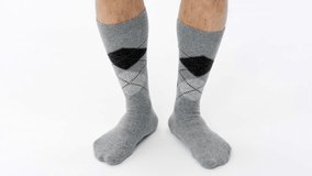 Gray Checkered Men's Socks. She dances with toes, heels and feet. It fits the Music Rhythm. Hairy male equipment shooting in white studio. E-commerce catalog video.