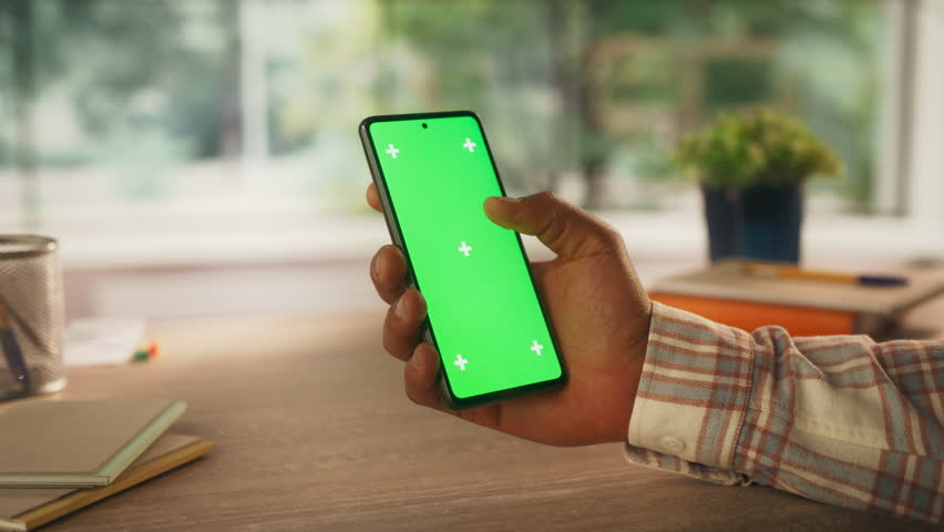 Anonymous Black Person Using a Smartphone with Mock Up Green Screen Chromakey Display with Motion Tracker Placeholders. Manager Browsing an App User Interface Online, Swiping and Tapping on the Phone Royalty-Free Stock Footage #1107300671