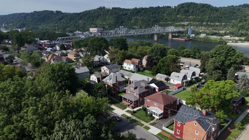 A slow forward aerial establishing shot view of a small Pennsylvania river town. Bridge over the Ohio River in the distance. Pittsburgh suburbs.  	