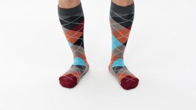 Checkered men's socks. Male model holding music beats and dancing from the front. E-commerce trend socks Promotion and advertising video. Shooting in a White Studio. Catalog shooting. Gift for men.