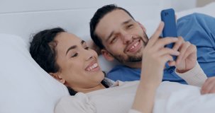 Couple, phone and reading in bed, morning and happy together for social media, chat or blog on holiday. Girl, smartphone and check email in bedroom with notification, video or meme with smile in home