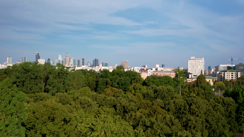 Aerial Panorama of Warsaw Downtown Cityscape in Backdrop of Lush Green Forest on Sunny Summer Day  Royalty-Free Stock Footage #1107306063