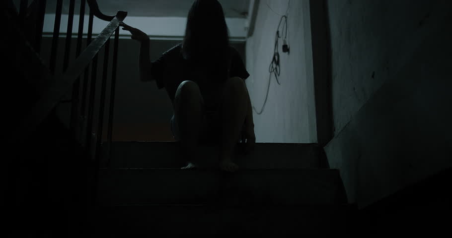 Horror scene of a mysterious Scary Asian ghost woman creepy have hair covering the face sitting on staircase at abandoned house with background dark scene movie at night, festival Halloween concept Royalty-Free Stock Footage #1107306497