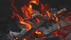 Firewood burning - slow motion video of Tongues of fire and smoke from coals in the grill