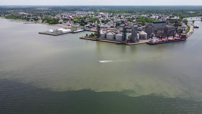 small tourist boat going out of the harbor into the river