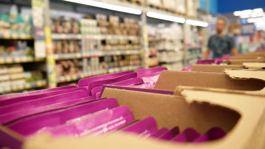 Many packages with jelly cat food in a supermarket and a male buyer takes a few Royalty-Free Stock Footage #1107320185