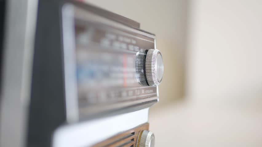 Blurred Shooting with a Man Rotating Radio Frequency Button and Searching a Radio Station with News or Music. Man Using an Old Radio Technology. Royalty-Free Stock Footage #1107322123