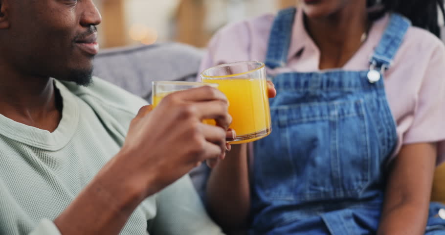 Toast, black couple and orange juice in home, happy and healthy diet, nutrition or wellness on living room sofa. Man, woman and drink cheers in fruit glass, organic vitamin c and vegan conversation