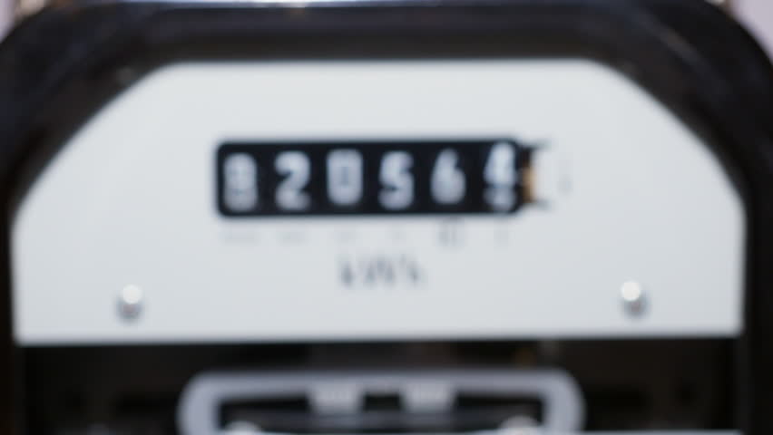 A close-up of a domestic electric meter and measuring dial numbers. Slow zoom-in out of focus to in focus. Concept, meter readings, power, energy, high bills, inflation and meter reading. kWh sign. Royalty-Free Stock Footage #1107329041