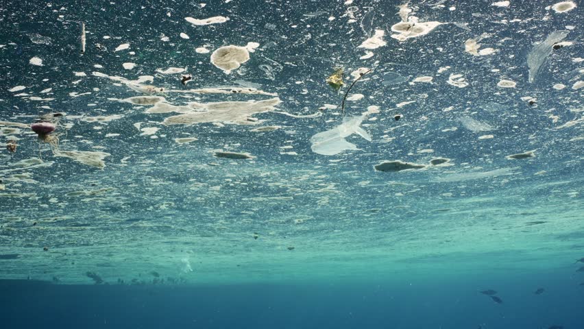 Polluted surface of ocean is covered with plastic and other waste. Plastic and other debris drifting in fatty oily layer. Vital activity of people's leading to environmental Issue plastic pollution  Royalty-Free Stock Footage #1107332473