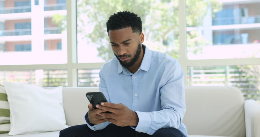 35s African man spend time on internet using modern smartphone, e-dating services for singles, on-line communication via social media networks, choose goods and e-services use marketplace webstore app Royalty-Free Stock Footage #1107333005